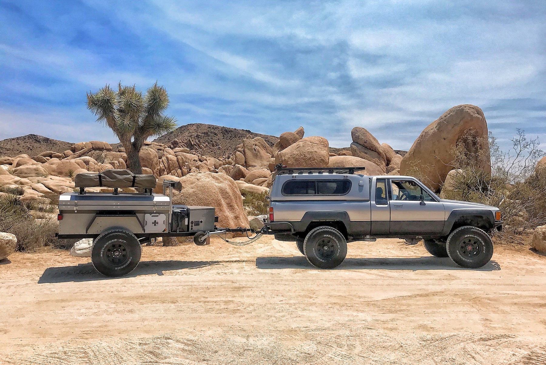 outdoor photo of a truck towing an overland rig for camping.