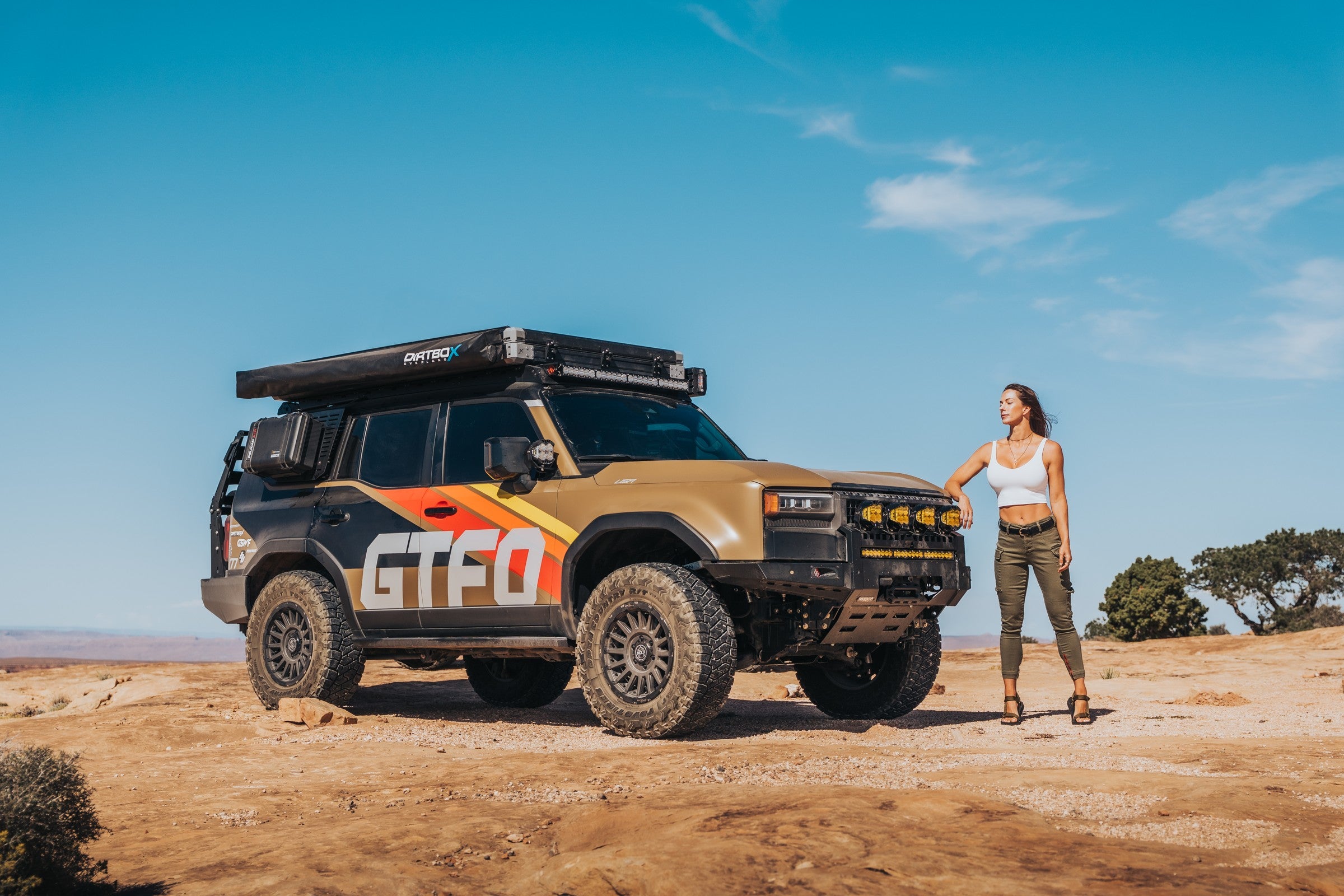 Janna beside the GTFO Land Cruiser on a desert outing
