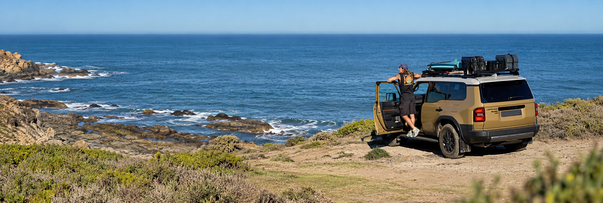 Front Runner roof rack carrying adventure gear on a Toyota Land Cruiser beside the coast