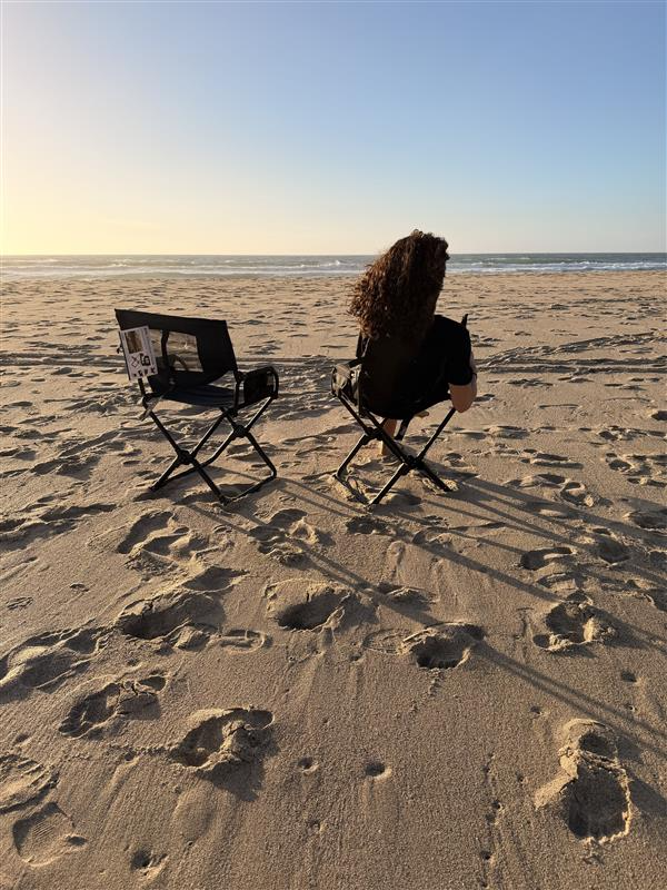 Two Front Runner Expander Chairs on the sand, with Janna seated facing the ocean in Monterey, California