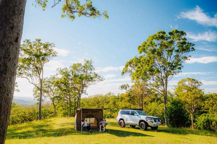 Oztent RV-3 tent and vehicle at a wooded campsite