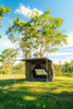Oztent RV-3 tent with its awning extended on a grassy campsite