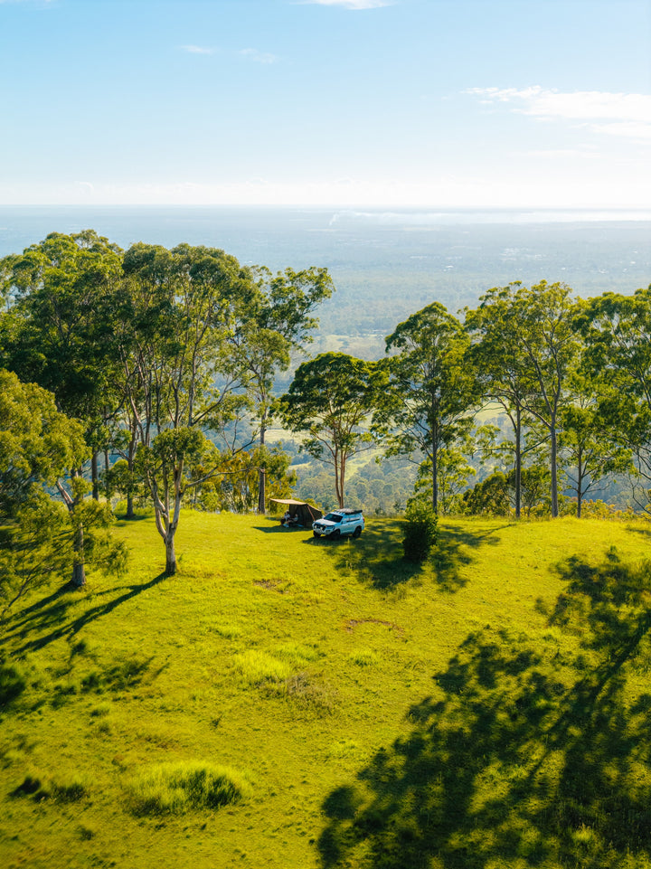 Wide campsite view with Oztent RV-3 tent among trees