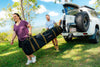 Campers carrying an Oztent RV-5 tent bag from their vehicle