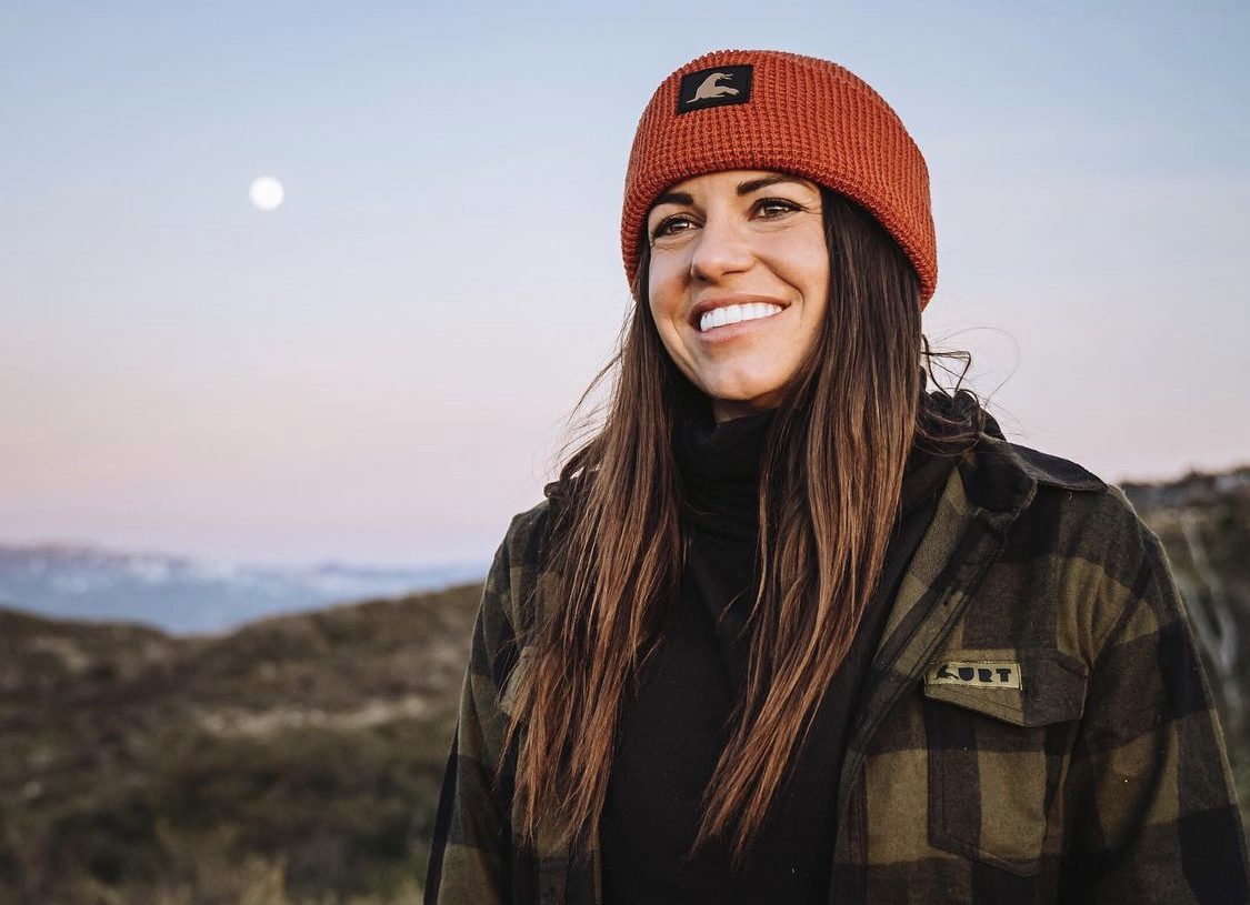 Laura Zerra outdoors wearing a red knit hat